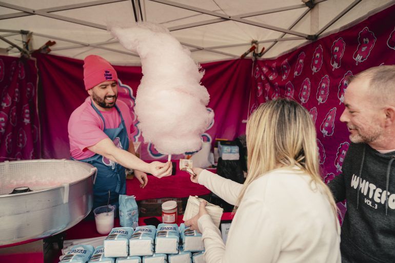 Man handing candyfloss to a couple